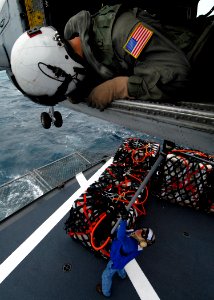 US Navy 070717-N-7981E-161 Aviation Warfare Systems Operator 2nd Class Tyler Yee, of the Golden Falcons of Helicopter Anti-submarine Squadron (HS) 2, relays information to the pilots of an HH-60H Seahawk