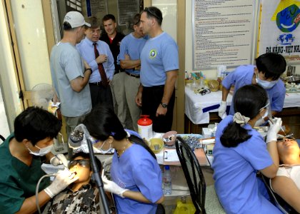 US Navy 070721-N-4954I-183 Jonathan Aloisi, deputy chief of mission of the U.S. Embassy in Hanoi, listens as Capt. Charles Craft, with U.S. Public Health Service, explains the dental work being done at Nai Hiem Dong Medical Sta