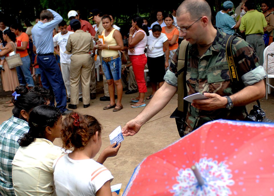 US Navy 070721-N-6278K-022 Mass Communication Specialist 2nd Class Steven King passes out Military Sealift Command hospital ship USNS Comfort (T-AH 20) postcards to patients at 15 de Julio Health Care Center