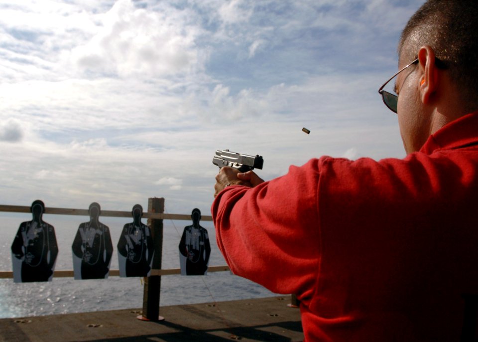 US Navy 070719-N-8132M-002 Chief Warrant Officer 2 Norman Gilbert, fires a 9mm handgun during small arms qualifications on the flight deck aboard nuclear-powered aircraft carrier USS Enterprise (CVN 65)