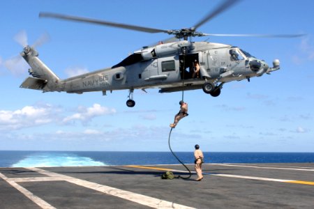 US Navy 070720-N-5928K-007 Explosive ordnance disposal technicians assigned to Explosive Ordnance Disposal Mobile Unit (EODMU) 2, Det. 26, conduct a fast rope exercise from an HH-60H Seahawk photo