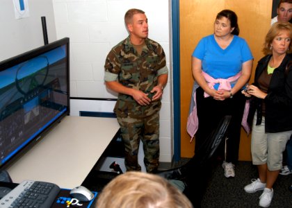 US Navy 070718-N-9860Y-030 Navy Diver 1st Class Paul Mehring, of Portland, Ore., describes how aviation personnel use the reduced-oxygen breathing device in relation to a flight simulator to a group of educators from Texas in t