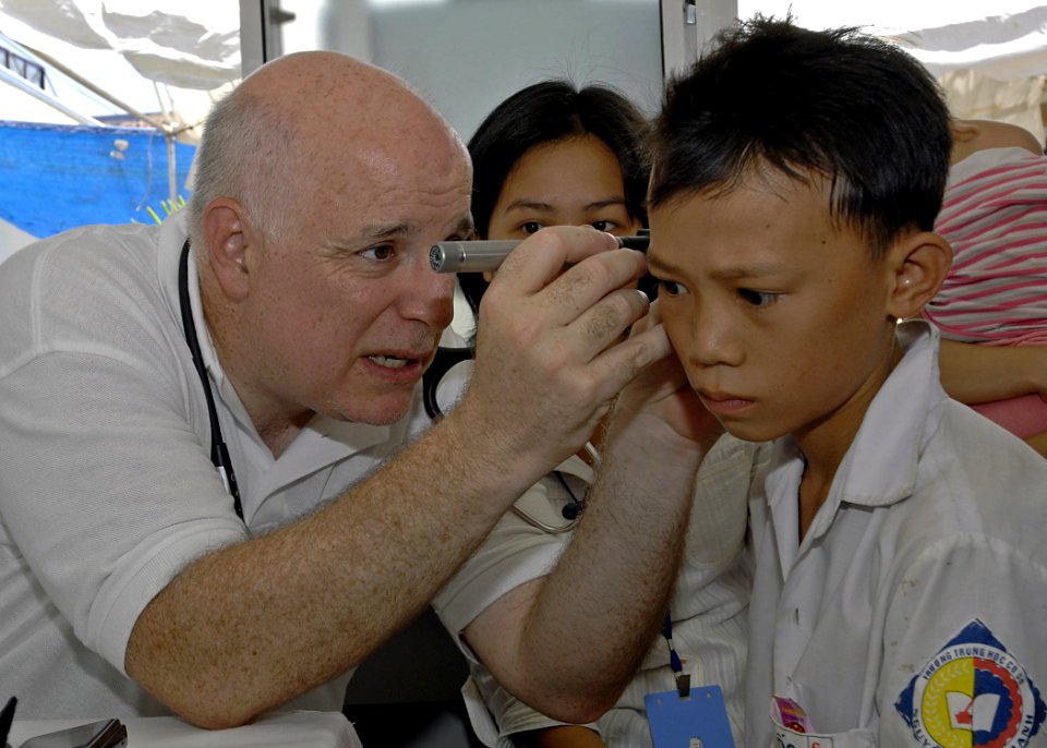 US Navy 070720-N-4954I-048 Dr. Dana Braner, part of the non-governmental organization Project Hope, examines a Vietnamese patient's ear at the Man Thai Ward Medical Station in support of Pacific Partnership 2007