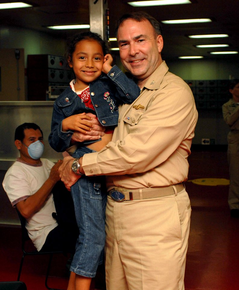 US Navy 070719-N-7088A-002 Capt. Bob Kapcio, mission commander aboard Military Sealift Command hospital ship USNS Comfort (T-AH 20), poses for a picture with a patient awaiting medical care