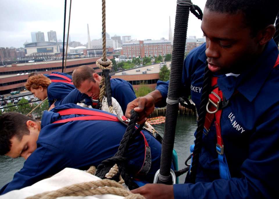US Navy 070723-N-2893B-001 Working with other USS Constitution Sailors on the ship's mizzenmast, Seaman Apprentice Tyrell Mackey ties a gasket to secure the topsail to the starboard yard