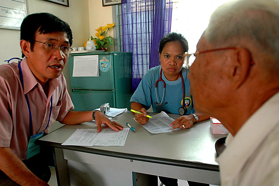 US Navy 070719-N-9421C-030 Lt. Cmdr. Leila Williams, attached to Naval Health Clinic Hawaii, awaits a response from an elderly Vietnamese man after communicating to an interpreter at Nai Hiem Dong Ward Station