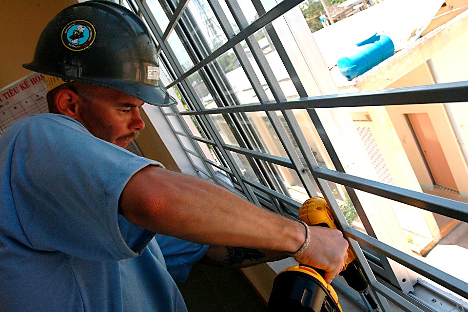 US Navy 070719-N-9421C-136 Steelworker 2nd Class Brian Castonguay, attached to Naval Mobile Construction Battalion (NMCB) 7, finishes installation of bars to windows at Mother's Love Clinic