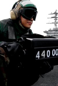 US Navy 070723-N-8119R-141 Airman Albert Ramirez operates the weight board on the flight deck of nuclear-powered aircraft carrier USS Nimitz (CVN 68)