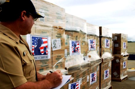 US Navy 070720-N-2143T-001 Capt. Robert Holley, stationed aboard Military Sealift Command ammunition ship USNS Flint (T-AE 32), checks the inventory list of popcorn cases