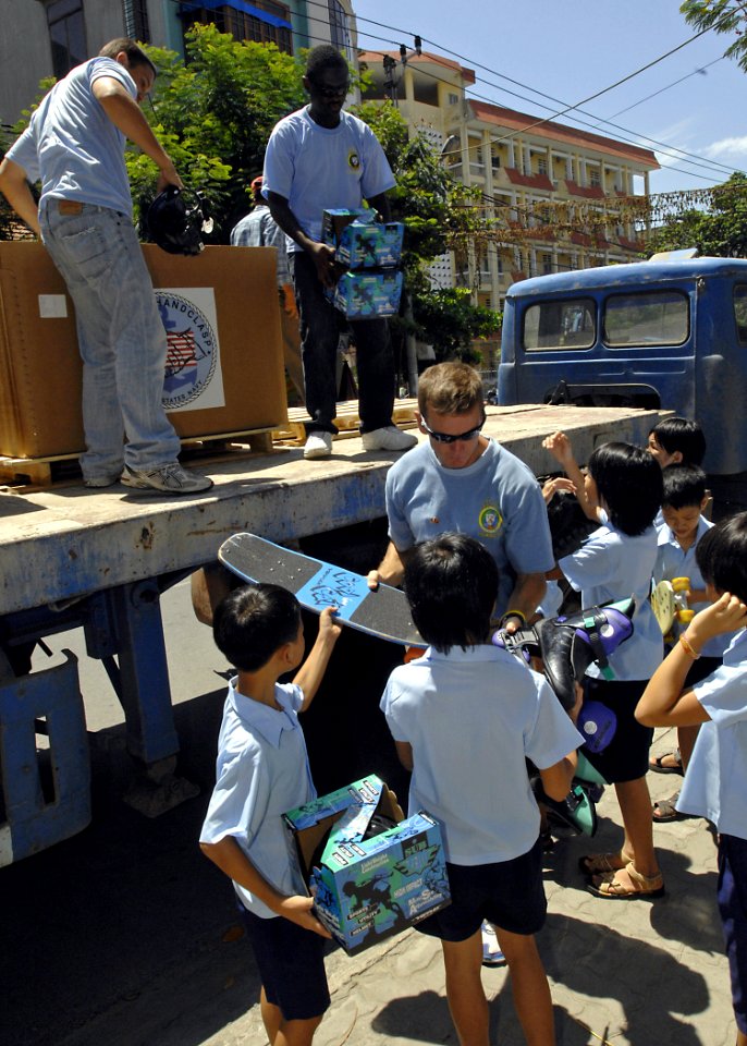 US Navy 070724-N-4954I-055 Capt. Bruce Stewart, Pacific Partnership mission commander, hands out donated toys as part of a Project Handclasp ceremony for the Children of Vietnam organization