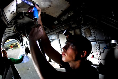 US Navy 070721-N-9760Z-017 Aviation Structural Mechanic Airman Nicholas Domber, assigned to the Black Ravens of Tactical Electronic Warfare Squadron (VAQ) 135, drills a screw off a panel inside the engine cavity of an EA-6B Pro