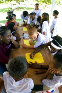 US Navy 070719-N-6674H-081 Yeoman 1st Class Nakia Habson, a volunteer drug education for youth (DEFY) mentor, coaches children enrolled in the phase-one summer camp as they work as a team to draw pictures depicting the days eve