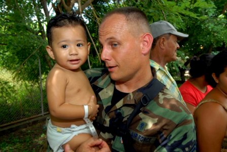 US Navy 070720-N-8704K-131 U.S. Air Force Senior Master Sgt. Steven Foster, attached to Military Sealift Command hospital ship USNS Comfort (T-AH 20) holds a one-year-old child at the 15 de Julio Health Care Center