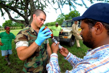 US Navy 070720-N-8704K-230 Master-at-Arms Seaman Jon Walsh, assigned to Military Sealift Command hospital ship USNS Comfort (T-AH 20), helps Nicaraguan Ministry of Agriculture and Forestry (MAGFOR) veterinarian Rigoberto Reyes