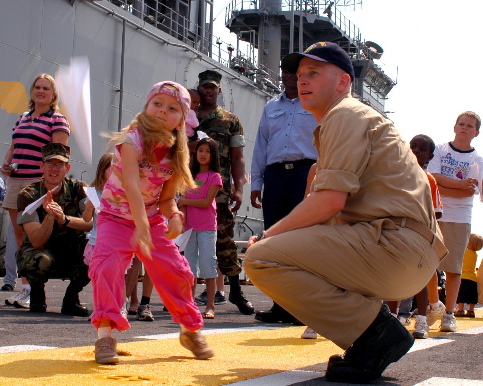 US Navy 070725-N-4014G-023 A young girl throws a paper airplane during a paper-airplane-throwing contest as part of Bring Your Child To Work Day aboard amphibious assault ship USS Kearsarge (LHD 3)