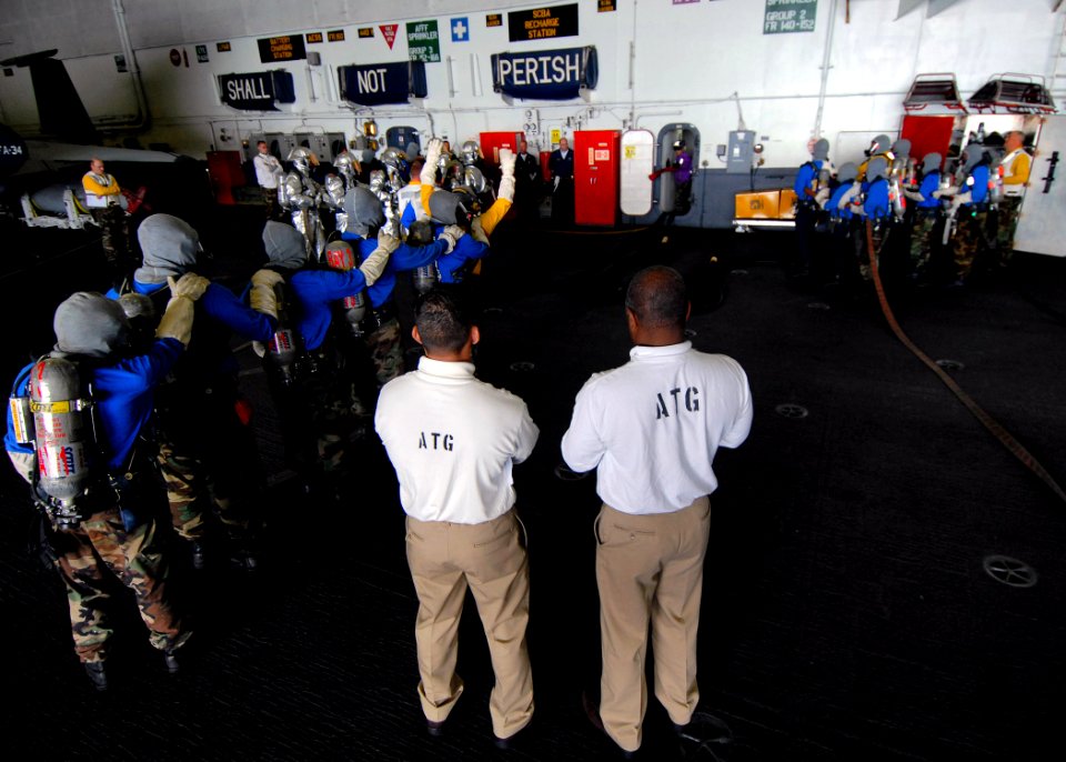 US Navy 070725-N-7981E-054 Members of Afloat Training Group (ATG) Pacific observe as personnel assigned to Air Department respond to a simulated hangar bay fire aboard Nimitz-class aircraft carrier USS Abraham Lincoln (CVN 72)