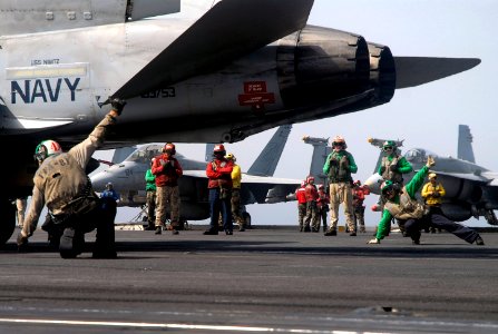 US Navy 070721-N-0890S-054 Sailors signal safe for launch prior to an F-A-18C Hornet, assigned to the Sunliners of Strike Fighter Squadron (VFA) 81, launching off the flight deck of the nuclear-powered aircraft carrier USS Nimi