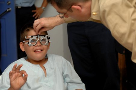 US Navy 070723-N-7088A-008 A deaf patient gives the OK sign to Lt. Cmdr. Brian Hatch, an optometrist attached to Military Sealift Command hospital ship USNS Comfort (T-AH 20), during an eye exam at the El Realejo Health Care Ce