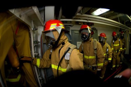 US Navy 070726-N-9864S-005 Hose team members enter a smoke boundary to combat a simulated fire during a general quarters drill aboard USS Kitty Hawk (CV 63)