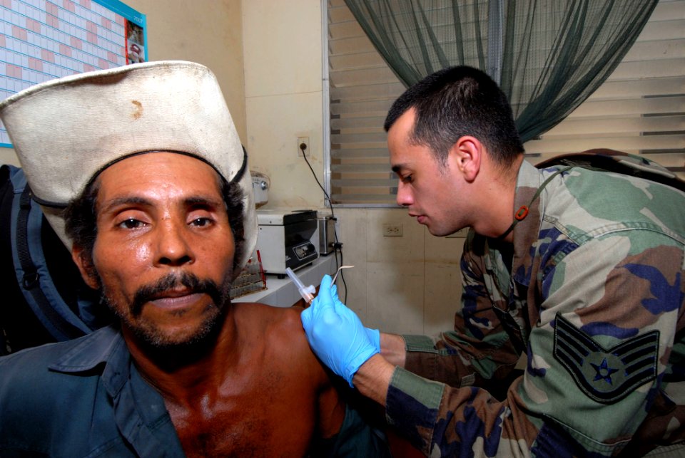 US Navy 070720-N-8704K-103 U.S. Air National Guard Staff Sgt. Christopher Flores, attached to Military Sealift Command hospital ship USNS Comfort (T-AH 20), gives Inhelio Lopez an immunization shot at the 15 de Julio Health Car
