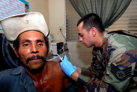 US Navy 070720-N-8704K-103 U.S. Air National Guard Staff Sgt. Christopher Flores, attached to Military Sealift Command hospital ship USNS Comfort (T-AH 20), gives Inhelio Lopez an immunization shot at the 15 de Julio Health Car