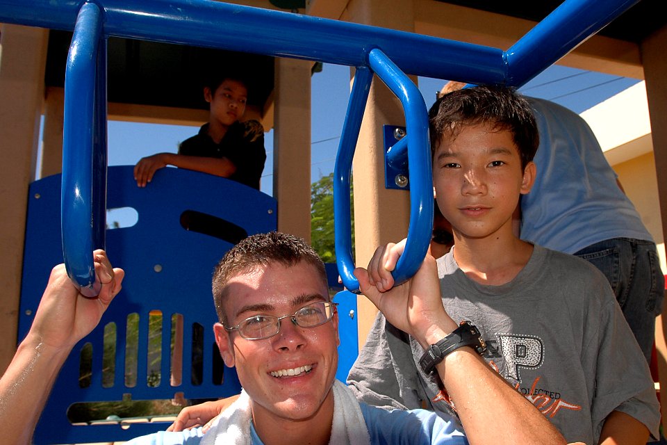 US Navy 070722-N-9421C-148 Hull Maintenance Technician Fireman Phillip Wright poses for a photo with a local Vietnamese child on a newly constructed playground set at Hoi Mai Orphanage during an engineering civic action program