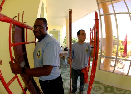 US Navy 070721-N-6669H-004 Religious Programs Specialist 2nd Class Fredrick Jones and Quartermaster Seaman Manuel Gomez help move scaffolding during an engineering civic action program at the Hoa Phouc Clinic in support of Paci