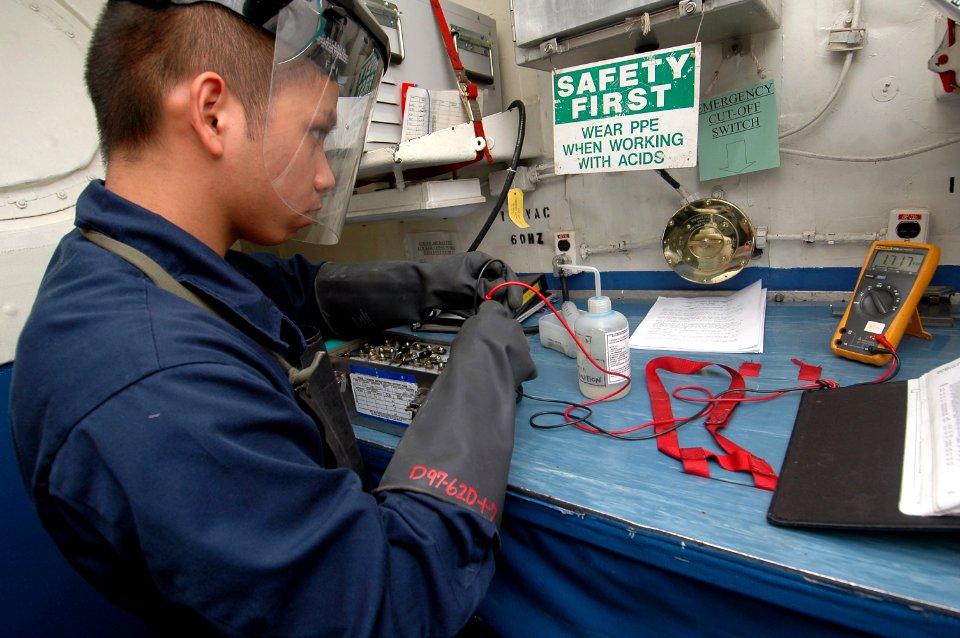 US Navy 070727-N-5387K-007 Aviation Electrician's Mate Airman Hiep Nguyen, from Atlanta, takes voltage readings from a SH-60B helicopter battery in the battery ship aboard USS Kitty Hawk (CV 63)