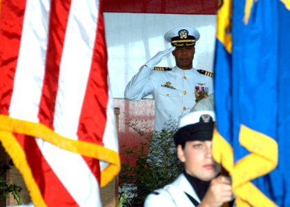 US Navy 070727-N-9860Y-017 Commanding Officer Naval Air Station Whidbey Island (NASWI), Capt. R. Sydney Abernethy III salutes the National Ensign during the NASWI change of command