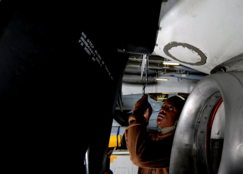 US Navy 070725-N-7981E-126 Aviation Machinist's Mate Airman Recruit Jeremy Smith, assigned to Carrier Airborne Early Warning Squadron (VAW) 116, torques screws on the aft spinner segment of a propeller on an E-2C Hawkeye