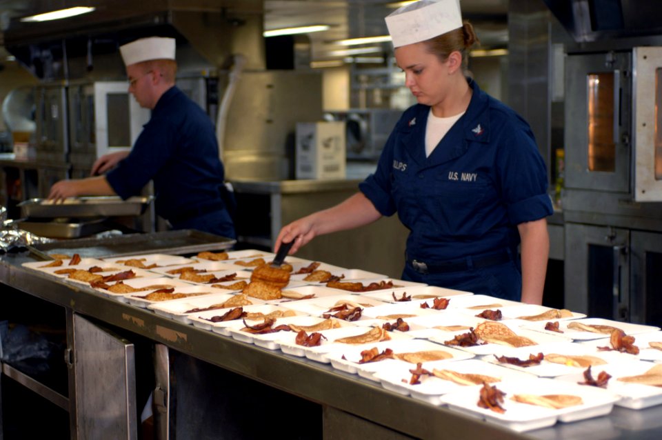 US Navy 070728-N-7088A-017 Culinary Specialist Seaman James Monoski and Fire Controlman 3rd Class Chelsea McKillips prepare meals for patients and their escorts in the galley aboard the Military Sealift Command hospital ship US