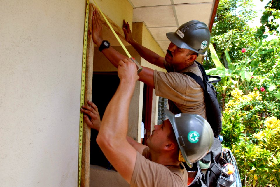 US Navy 070724-N-4238B-125 Construction Mechanic 1st Class William Schneider and Equipment Operator 1st Class Manuel Gradillas, attached to Military Sealift Command hospital ship USNS Comfort (T-AH 20), build a door frame at Jo