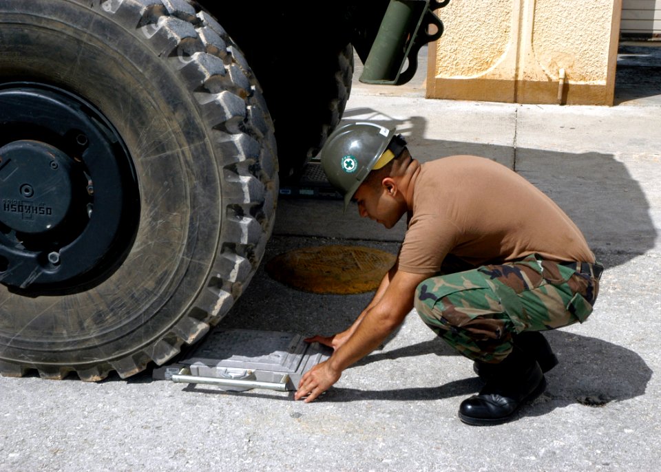 US Navy 070725-F-8678B-015 Construction Mechanic Constructionman Recruit Oscar C. Delarosa positions scales to obtain the axel weight of a High Mobility Multipurpose Wheeled Vehicle during a Fish Hook exercise