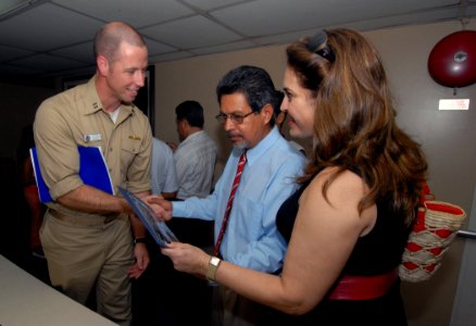 US Navy 070729-N-6081J-062 Lt. Taylor Clark, assigned to the public affairs office aboard the Military Sealift Command hospital ship USNS Comfort (T-AH 20), presents Salvadoran congressman Carlos Castaneda and his wife, Gertru