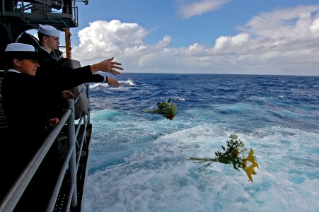 US Navy 070726-N-7883G-012 Yeoman Seaman Jessica Gardner and Yeoman Seaman Whitney Utter throw flowers overboard as USS Kitty Hawk (CV 63) passes the final resting place of USS Lexington (CV 2)