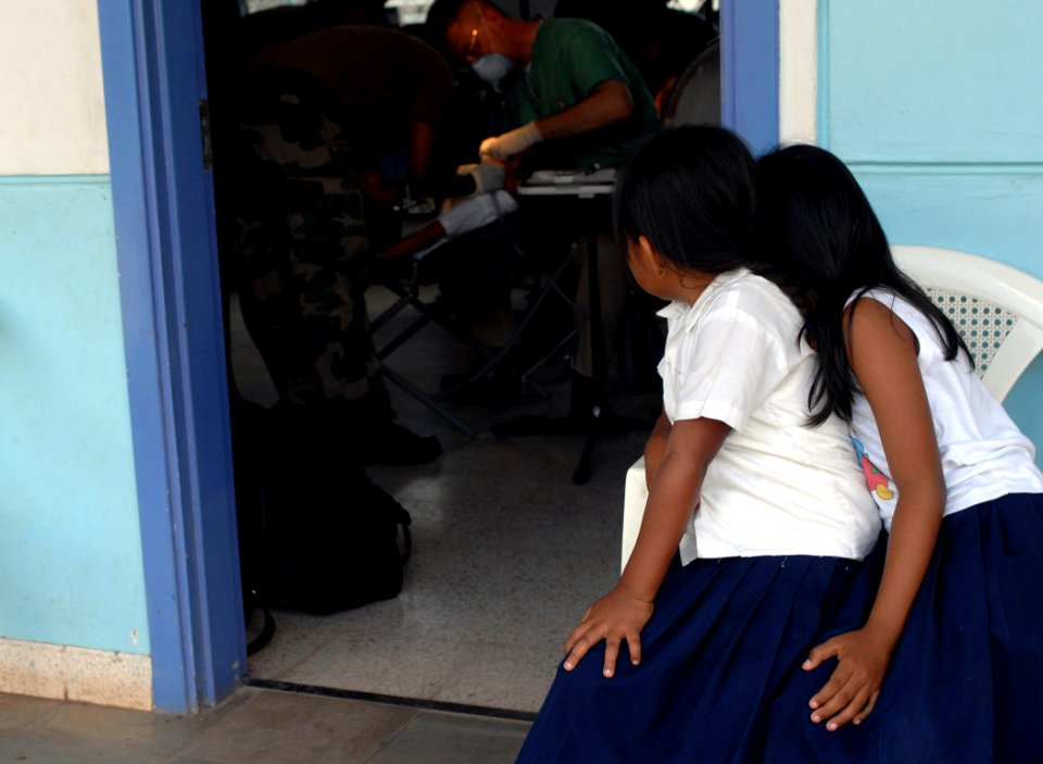 US Navy 070723-N-7088A-006 Two students from a local school watch as a fellow classmate receives dental care at the El Realejo Health Care Center, where medical personnel attached to Military Sealift Command (MSC) hospital ship