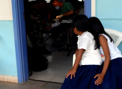 US Navy 070723-N-7088A-006 Two students from a local school watch as a fellow classmate receives dental care at the El Realejo Health Care Center, where medical personnel attached to Military Sealift Command (MSC) hospital ship photo