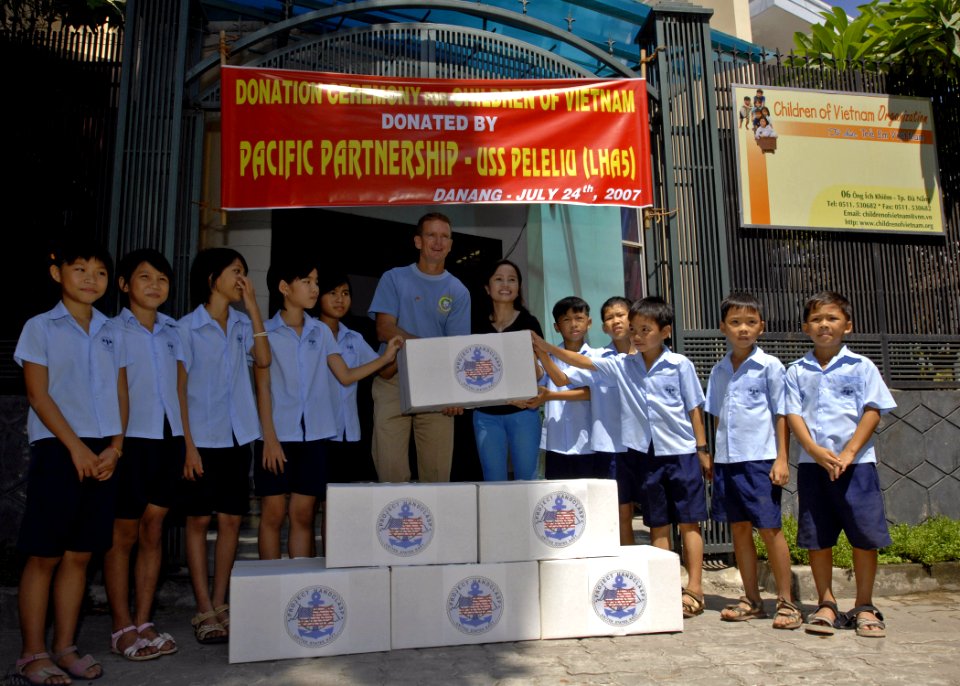 US Navy 070724-N-4954I-019 Capt. Bruce Stewart, Pacific Partnership mission commander, presents a donation from Luong Thi Huong, Project Handclasp program director, at the Children of Vietnam organization