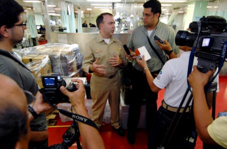 US Navy 070725-N-0194K-011 Capt. Bob Kapcio, mission commander aboard Military Sealift Command (MSC) hospital ship USNS Comfort (T-AH 20), speaks with local media from El Salvador in the casualty and receiving area, while touri