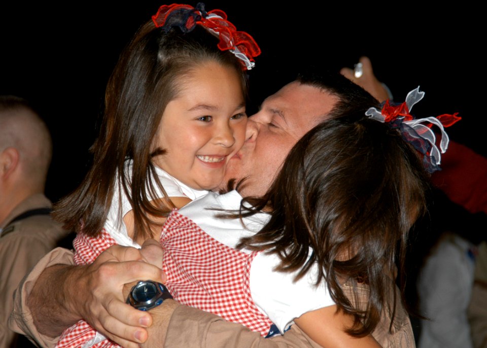 US Navy 070730-N-9860Y-019 Lt. Cmdr. Joe Vandelac, of St. Paul, Minn., kisses his daughters as the Electronic Attack Squadron (VAQ) 134 is welcomed back to Naval Air Station (NAS) Whidbey Island
