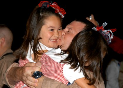 US Navy 070730-N-9860Y-019 Lt. Cmdr. Joe Vandelac, of St. Paul, Minn., kisses his daughters as the Electronic Attack Squadron (VAQ) 134 is welcomed back to Naval Air Station (NAS) Whidbey Island