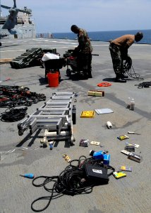 US Navy 070725-N-7088A-053 Members of Construction Battalion Maintenance Unit (CBMU) 202 sort and pack gear on the flight deck of Military Sealift Command hospital ship USNS Comfort (T-AH 20) in preparation for work in El Salva photo