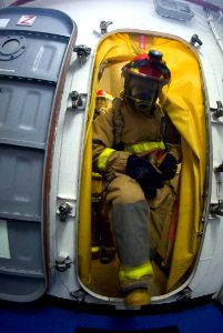 US Navy 070726-N-9864S-004 Seaman Robert Busch from Seattle, enters a room to fight a simulated fire during a general quarters drill aboard USS Kitty Hawk (CV 63)