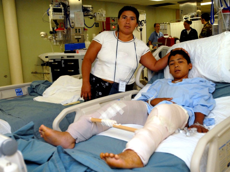 US Navy 070731-N-4238B-014 A young boy and his mother pose for a photo in the intensive care unit aboard hospital ship USNS Comfort (T-AH 20), while he recovers after a surgery on his legs