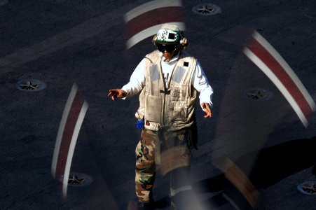 US Navy 070728-N-5387K-055 Aviation Structural Mechanic 2nd Class John Mayo, 25, from Los Angeles, directs an E-2C Hawkeye aboard the USS Kitty Hawk (CV 63) flight deck