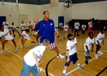 US Navy 070730-N-7427G-001 Duane Bowe, a member of the Harlem Globetrotters instructs students during a basketball camp held on Naval Air Station, Joint Reserve Base, New Orleans photo