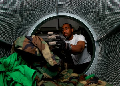 US Navy 070802-N-1229B-029 Ships Serviceman 3rd Class Terrence Daye loads one of the ship's dryers in the ship's service laundry aboard the Nimitz-Class aircraft carrier USS Abraham Lincoln (CVN 72) photo