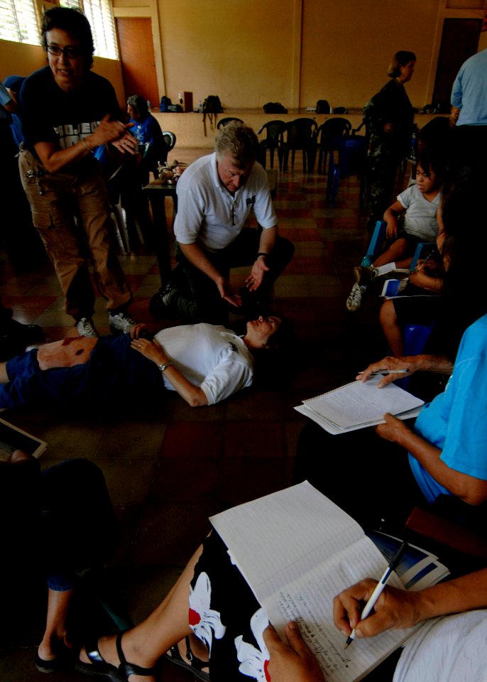US Navy 070729-N-6278K-190 Lupe Diaz, a Project Hope certified nurse midwife, and Bob Leitch, medical director for the Project Hope detachment aboard Military Sealift Command hospital ship USNS Comfort (T-AH 20), demonstrate fi