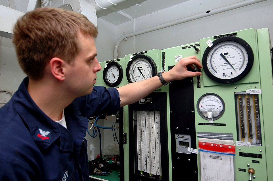 US Navy 070727-N-5387K-004 Aircrew Survival Equipmentman 2nd Class James Hardy, from Webster, N.H., adjusts the gauges on a oxygen regulator test stand in the aviation oxygen shop aboard USS Kitty Hawk (CV 63)