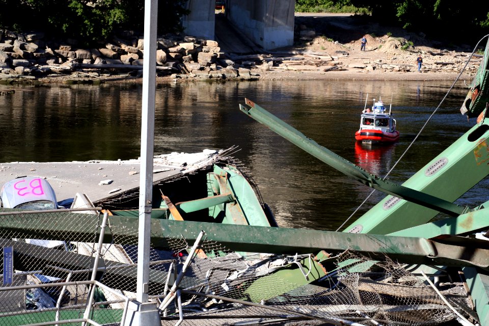 US Navy 070802-G-9386V-001 A 25-foot U.S. Coast Guard small boat patrols a safety zone at the bridge collapse site in Minneapolis
